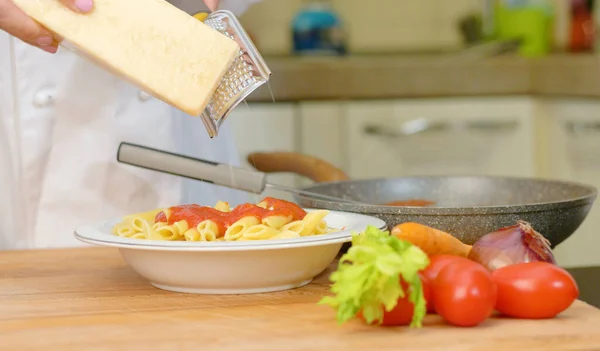 Chef Reibt Den Parmesan Über Die Nudeln Mit Tomatensauce — Stockfoto