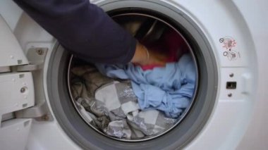 Yıkama döngüsünü hazırlıyorum. Çamaşır makinesi, eller ve elbiseler.