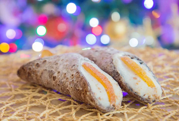 オレンジとシチリアのカノーロは背景としてクリスマスライトと果物を砂糖漬け — ストック写真