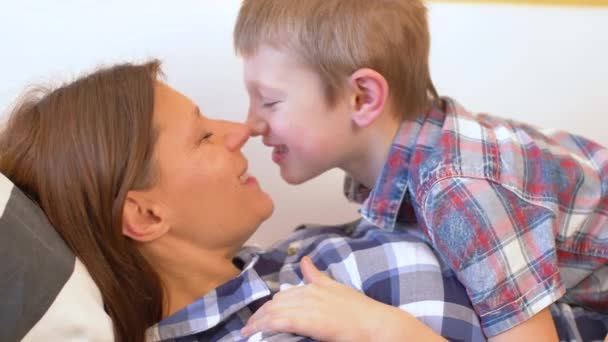 年轻妈妈和她的儿子在家里的沙发上拥抱和爱抚 — 图库视频影像