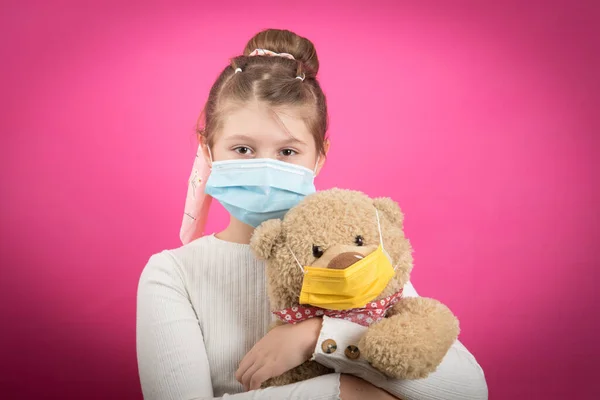 Młoda Dziewczyna Nosi Maskę Medyczną Koronawirusa Trzymając Swojego Misia Odizolowanego — Zdjęcie stockowe