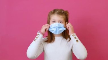 Güzel kız tıbbi maskeni çıkar ve özgürlük için gülümse.