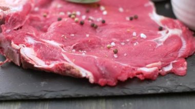 Lezzetli çiğ pirzola, tuz, biber ve yağlı levha.