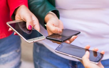 Akıllı telefonunu kullanan ve birbirlerinin fotoğraflarını paylaşan kadınlara yakın durun.