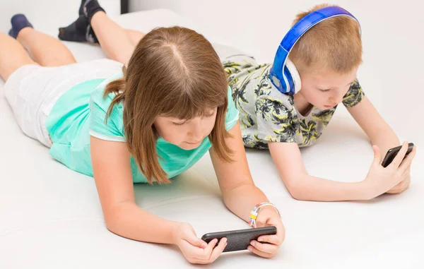 Broer Zus Kijken Naar Mobiele Telefoons Luisteren Naar Muziek Bank — Stockfoto