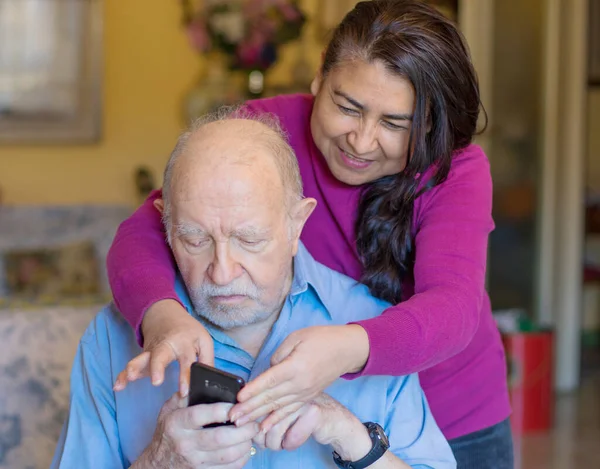 笑着拿智能手机的老人和护理人员正在做一个视频监控 — 图库照片