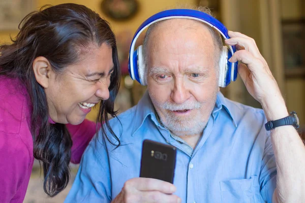 Usmívající Starší Muž Pečovatel Chytrým Telefonem Poslouchají Hudbu Sluchátkem — Stock fotografie