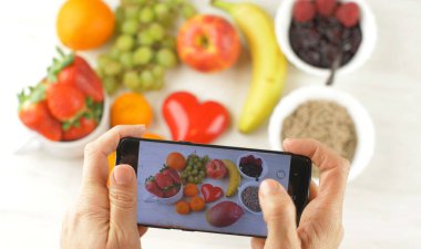 Birisi lezzetli kahvaltıya fotoğraf çekiyor.