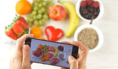 Birisi lezzetli kahvaltıya fotoğraf çekiyor.