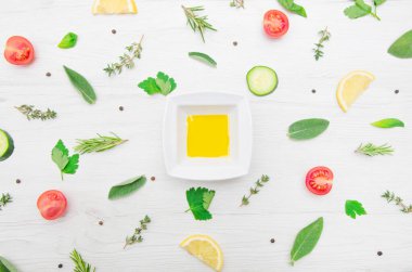 Çeşitli aromatik bitki yapraklarının üst görüntüsü ve ahşap arka planda kesilmiş sebzeler