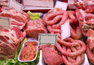 Bir kasap dükkanının tezgahında çeşitli et çeşitleri sergileniyor.