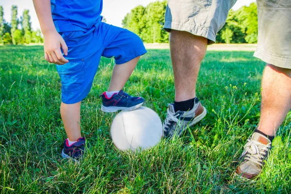 Baba oğul futbol topuyla oynuyorlar. 