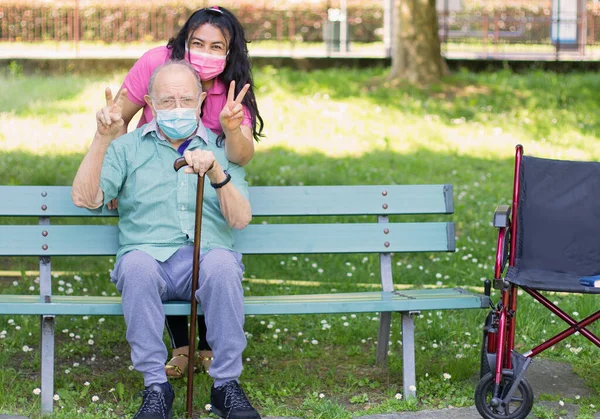 Glückliche Patientin Hält Pflegerin Der Hand Während Sie Zeit Miteinander lizenzfreie Stockfotos