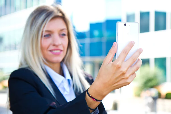 Hermosa mujer de negocios toma una selfie con su teléfono celular — Foto de Stock