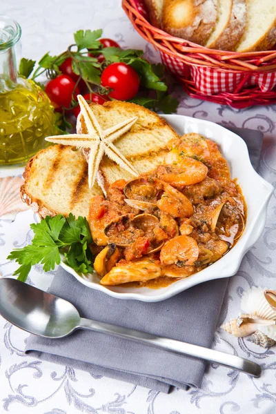 Fish soup with grilled polenta on crock pot — Stock Photo, Image