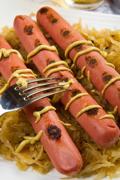 Bavarian fried sausages on sauerkraut — Stock Photo, Image