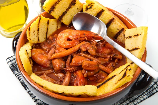 Fish soup with grilled polenta on crock pot — Stock Image Fish soup with grilled polenta on crock pot Royalty Free Stock Photos