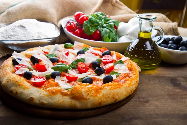 Lahodná čerstvá pizza podávaná na dřevěném stole — Stock fotografie