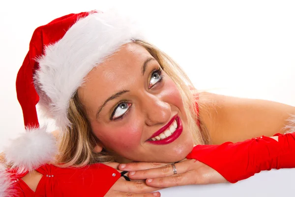 Vacker jul kvinna i tomte hatt håller tom styrelse — Stockfoto