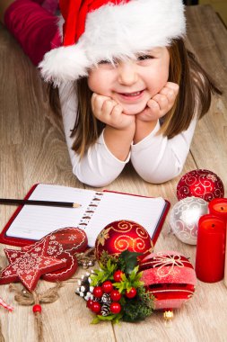 Noel Baba şapkalı kız Noel dekorasyonu Noel Baba'ya mektup yazar