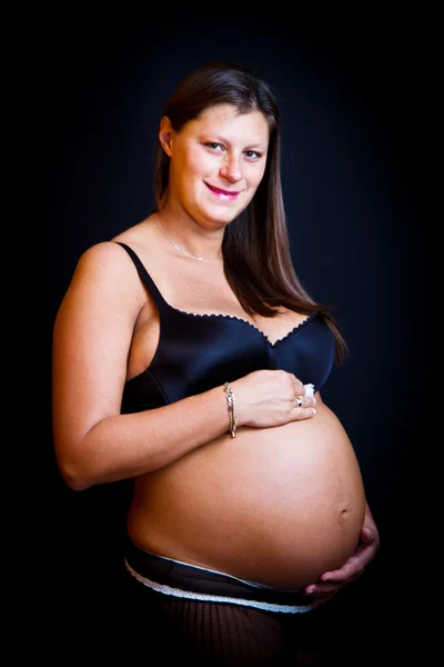 Belleza embarazada sobre fondo negro —  Fotos de Stock