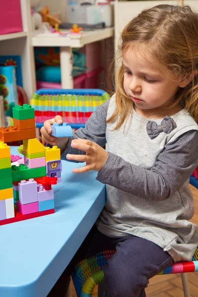 Little girl is playing with building bricks — Stock Photo, Image