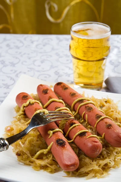 Bavarian fried sausages on sauerkraut — Stock Photo, Image