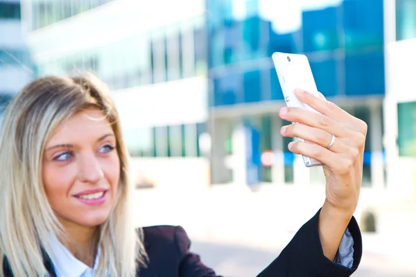 美しいビジネスの女性は彼女の携帯電話で、selfie を取る — ストック写真