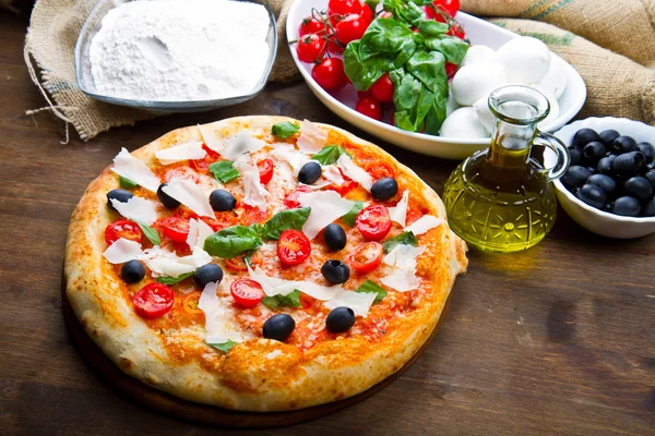 Läcker färsk pizza serveras på träbord — Stockfoto