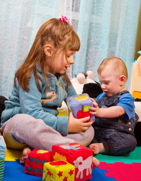 Brother and sister playing with soft colored cube — Stock Photo, Image