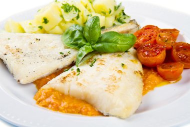Patates ve domates soslu taze siyah morina balığı.