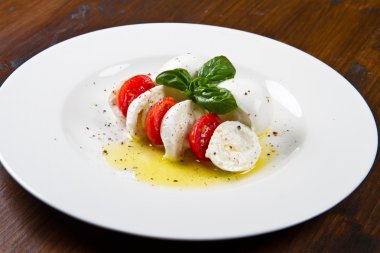 domates ve mozzarella ile fesleğen yaprakları bir plaka üzerinde