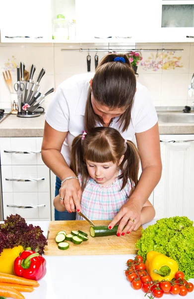 Mother and daughter in kitchen preparing vegetables — Stock Photo, Image