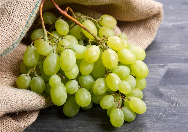 Racimo de uvas verdes sobre fondo de madera —  Fotos de Stock