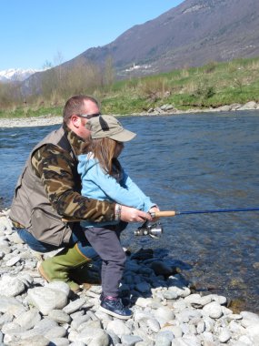  Neşeli baba ve kız birlikte nehirde balık tutma