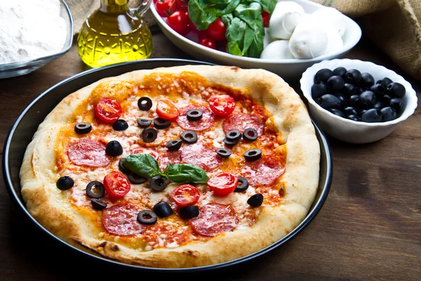 Pyszna świeża pizza serwowana na drewnianym stole — Zdjęcie stockowe