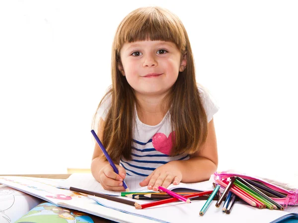 Милая маленькая девочка пишет за столом — стоковое фото