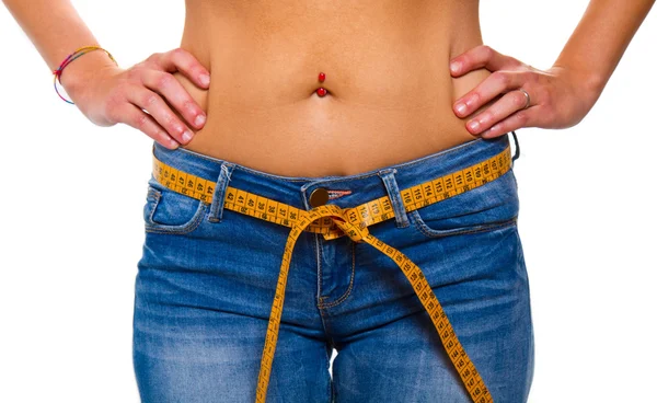 Uma jovem esbelta em jeans com uma fita métrica após uma sucção — Fotografia de Stock