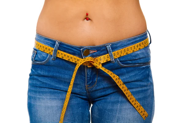 Uma jovem esbelta em jeans com uma fita métrica após uma sucção — Fotografia de Stock