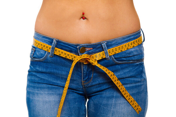 a slender young woman in jeans with a tape measure after a succe