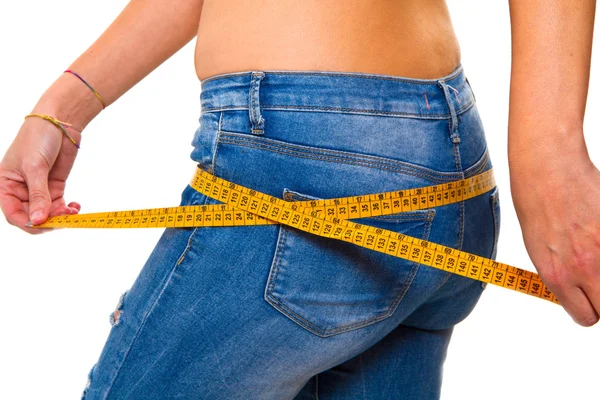Una joven esbelta en jeans con una cinta métrica después de un éxito —  Fotos de Stock