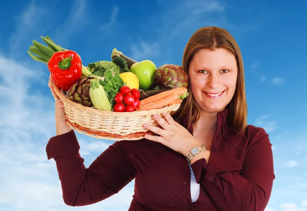 Menina com uma cesta cheia de legumes — Fotografia de Stock