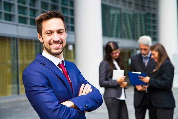 Hermoso hombre en el fondo de la gente de negocios — Foto de Stock