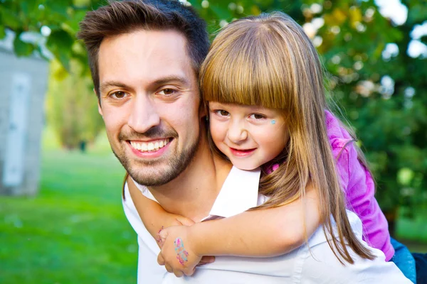 Petite fille marchant sur les épaules de son frère dans le parc — Photo