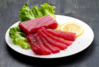 Ahşap backgr beyaz tabak üzerinde ham mavi yüzgeçli orkinos sashimi dilim