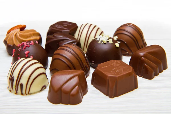 Un surtido de chocolates finos en chocol blanco, oscuro y de leche — Foto de Stock