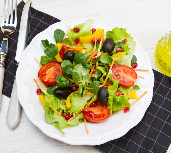 Salada mista com tomates em placa branca na mesa de madeira — Fotografia de Stock