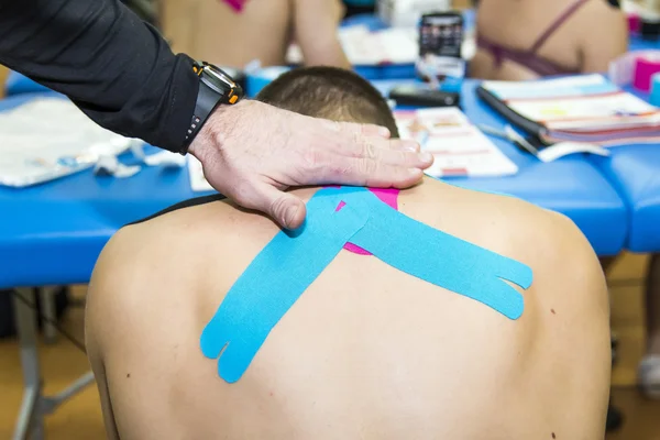 Masseren van jonge man - kinesiotaping — Stockfoto