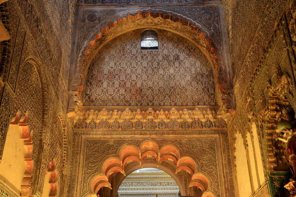 Интерьер мезкитского собора Кордовы демонстрирует свои характерные красно-белые полосатые арки и опорные колонны под теплым светом..