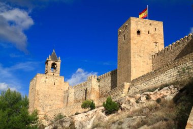 Antik Alcazaba kalesi ve kilise çan kulesi İspanya 'nın Antequera kentindeki beyazlatılmış büyüleyici köyün üzerindeki manzaraya hükmediyor..